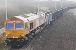 Engine in Biffa livery hauling long freight train